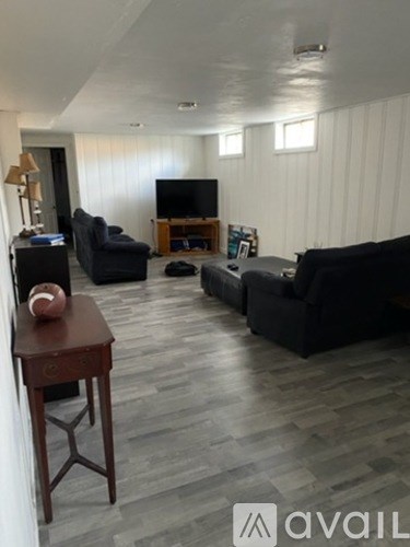 A living room with a television, couches, and a wooden table.