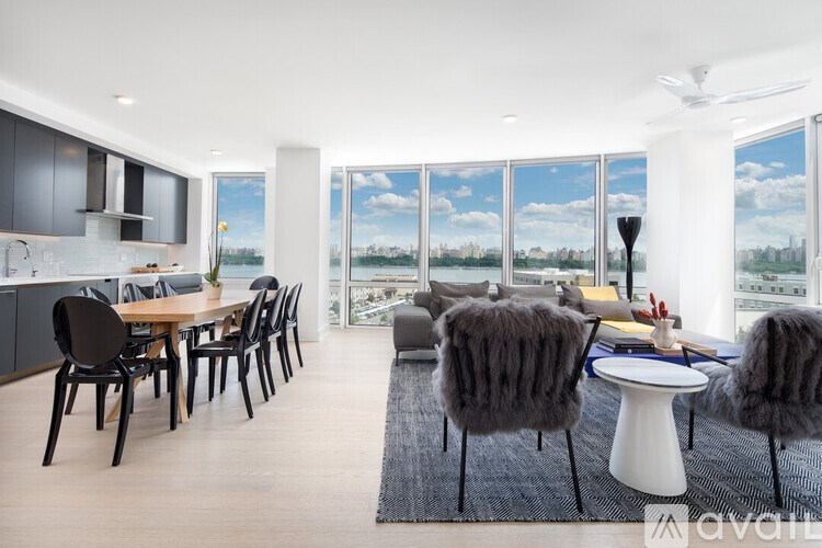 A modern dining room with a view of the cityscape outside the large windows.