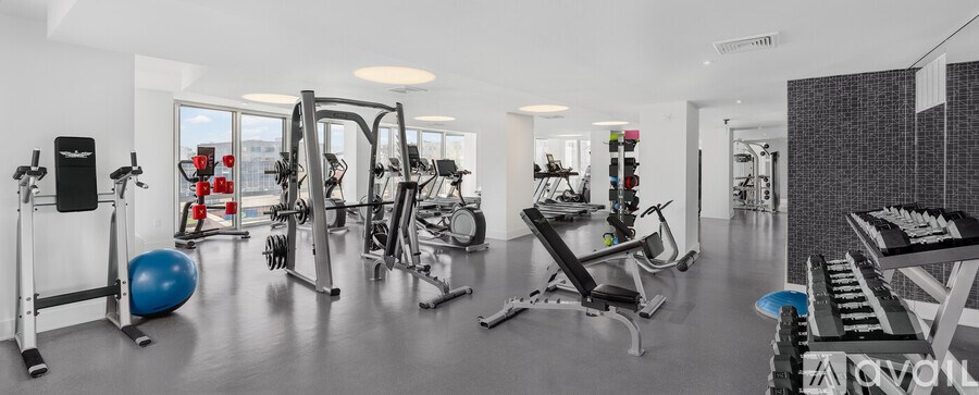 A gym with a variety of equipment including weights, a bench press, and a leg press machine.