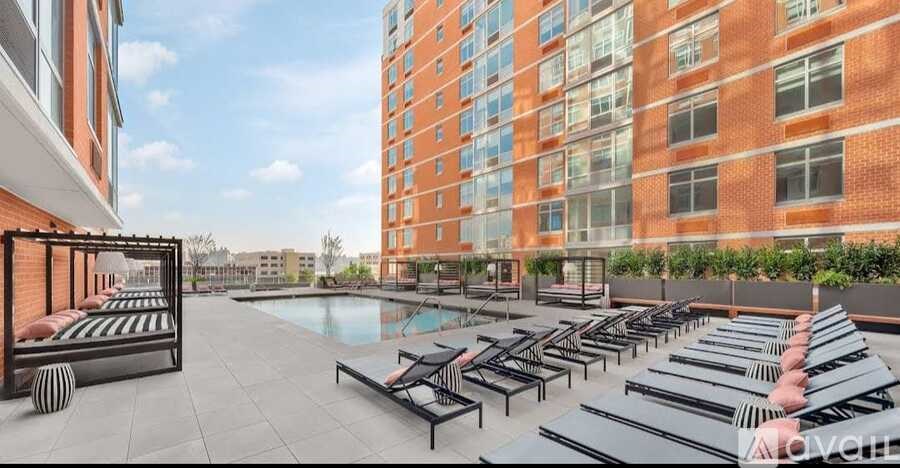 A rooftop patio with sun loungers and a pool.