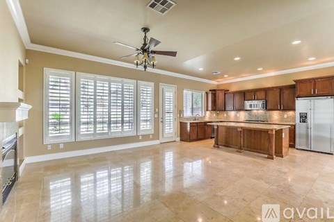 A spacious kitchen with a ceiling fan and a dining area with a table and chairs.