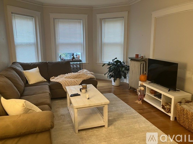 A room with wooden floors and two windows.