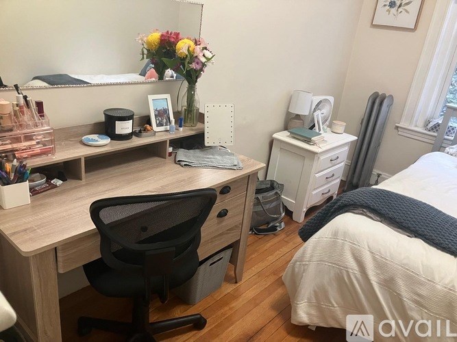 A room with wooden floors and a lamp on the left side.