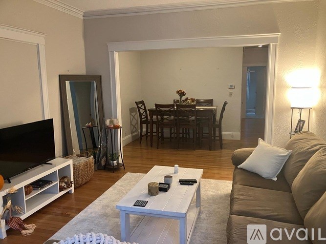 A hallway with a door at the end and a thermostat on the wall.