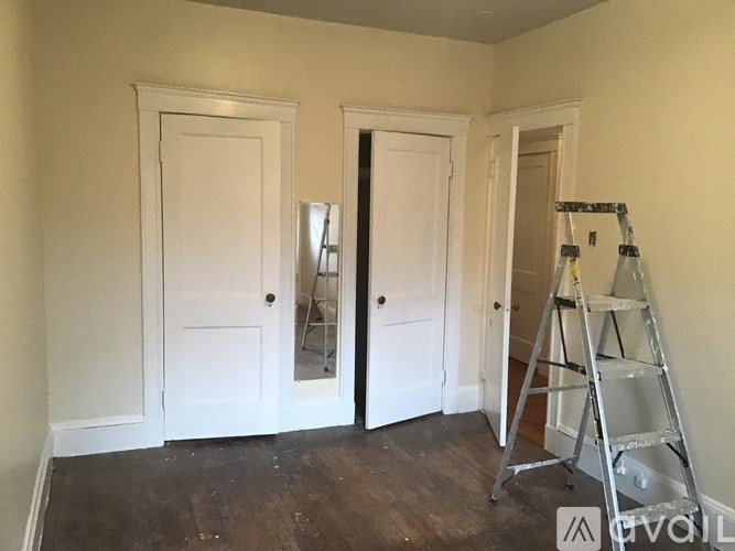 A room with white doors and a wooden floor is being renovated.