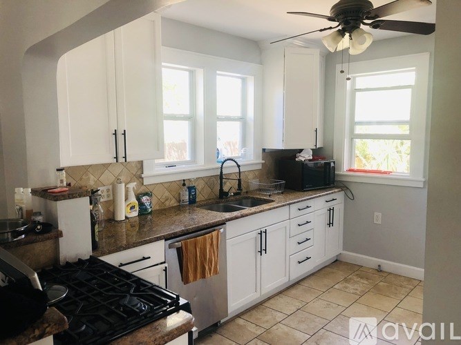 A kitchen with white cabinets and a black stove top.