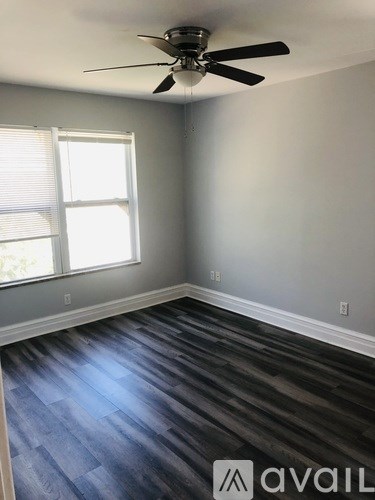 A room with a ceiling fan and a window.