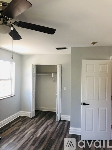A room with a ceiling fan and a door.