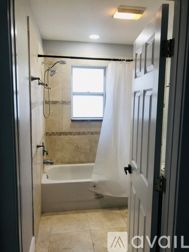 A bathroom with a tub and a window.