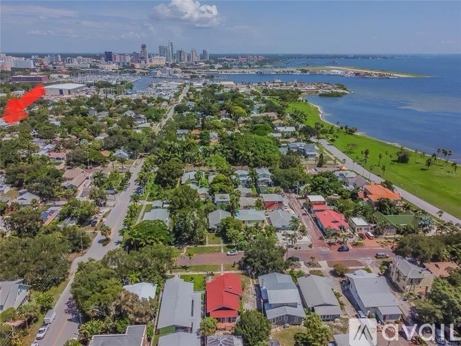 An aerial view of a residential area with a red arrow pointing to a specific location.