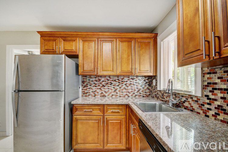 A kitchen with wooden cabinets and a silver refrigerator.