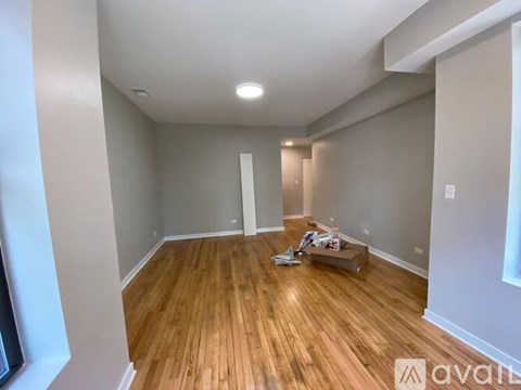A room with wooden flooring and white walls is available for rent.