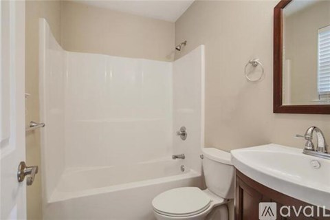 A bathroom with a toilet, sink, and bathtub.