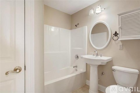 A bathroom with a white sink, toilet, and bathtub.