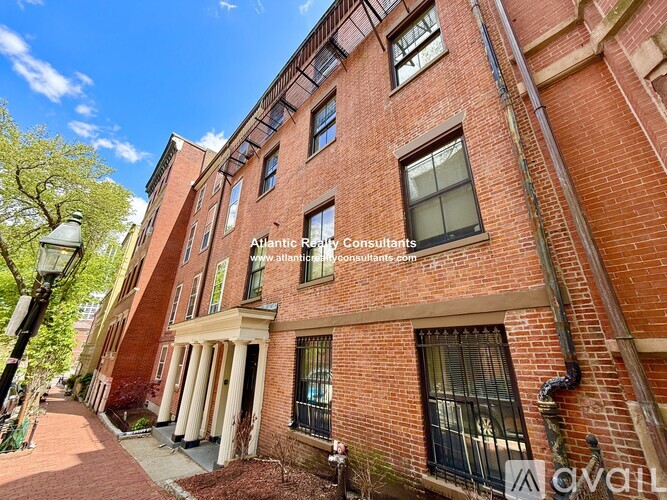 A red brick building with a sign for Atlantic Realty Consultants on the front.