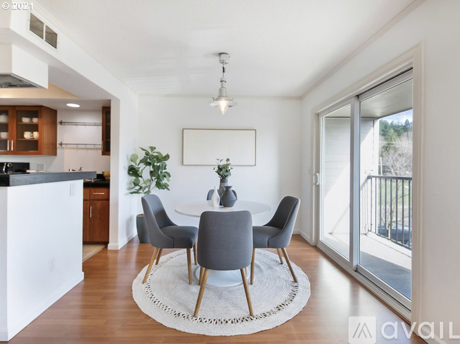 A modern dining room with a white table and grey chairs.