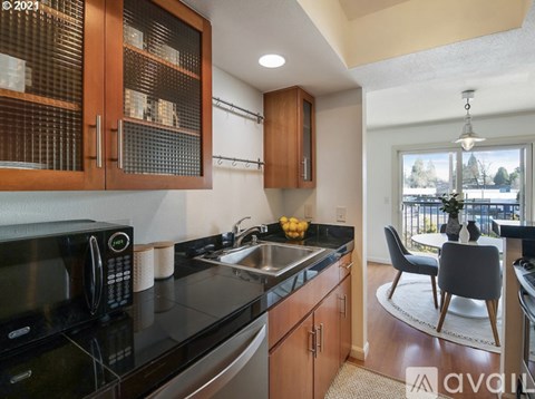 A kitchen with wooden cabinets and a black countertop.