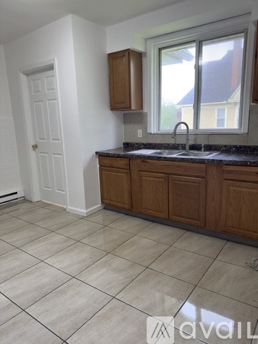 A kitchen with wooden cabinets and a window.
