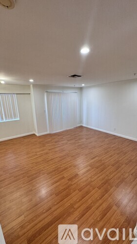 A room with wooden flooring and white walls.