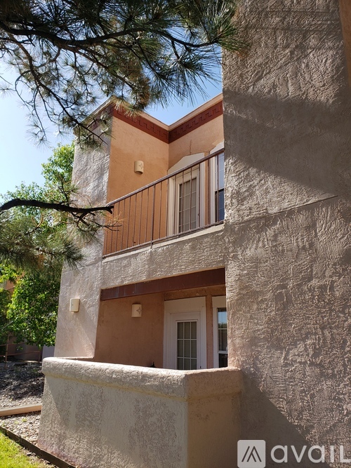 A building with a balcony and a door is shown.