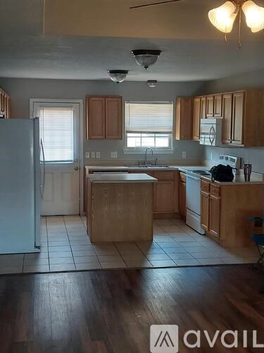 A kitchen with wooden cabinets and a white refrigerator.