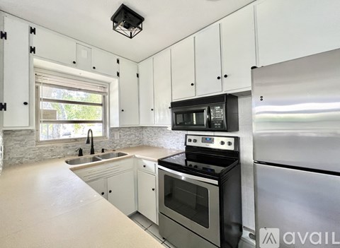 A kitchen with white cabinets and stainless steel appliances.