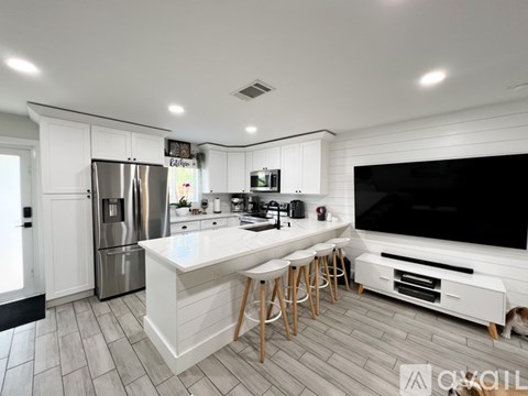 A modern kitchen with white cabinets and a large island.