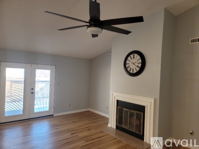A living room with a fireplace and a ceiling fan.