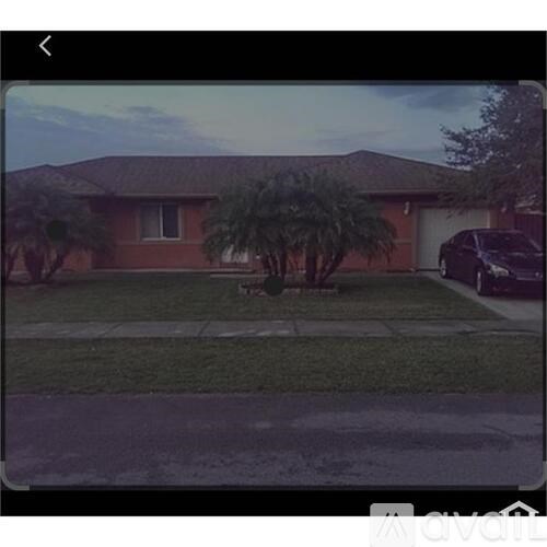 A house with a brown roof and a tree in front.