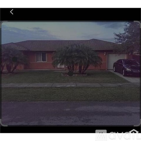 A house with a brown roof and a tree in front.