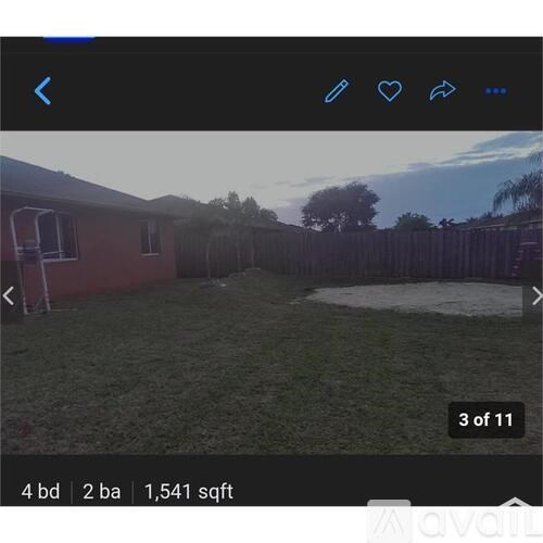 A backyard with a fence and a house.