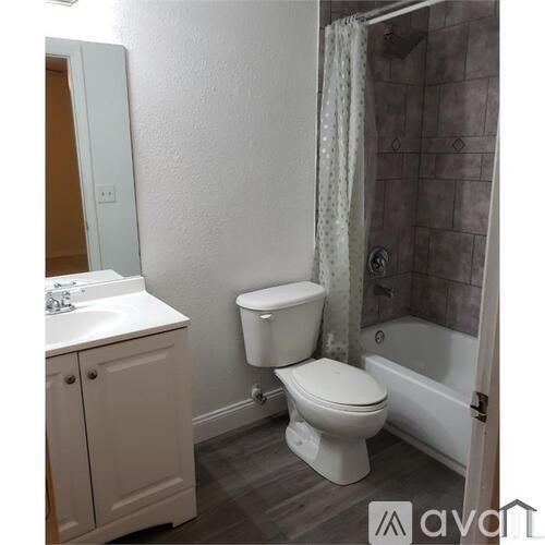 A bathroom with a toilet, sink, and bathtub.