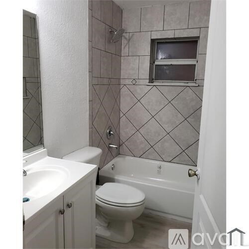 A bathroom with a toilet, sink, and bathtub.