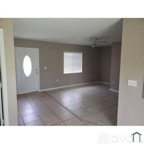 A room with a white door and a window with blinds.