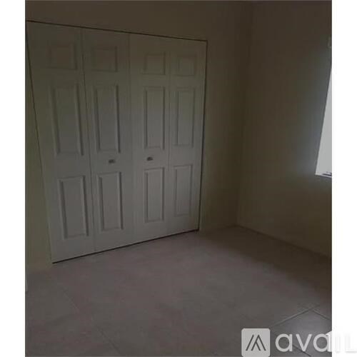A white double door in a room with tiled flooring.
