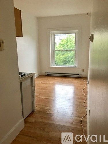 A room with a window and a wooden floor.