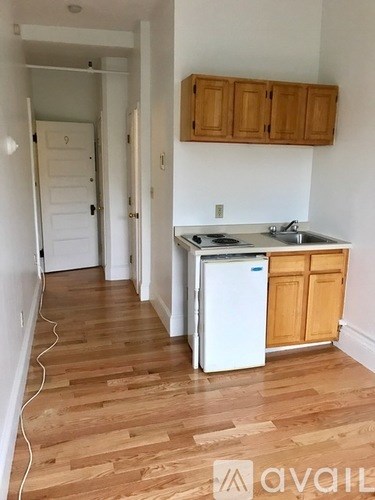 A kitchen with wooden cabinets and a white fridge.
