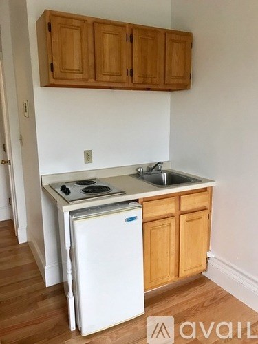 A kitchen with wooden cabinets and a white fridge.