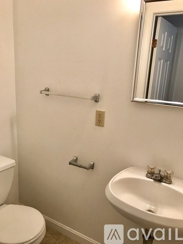 A white toilet sits next to a white sink in a bathroom.