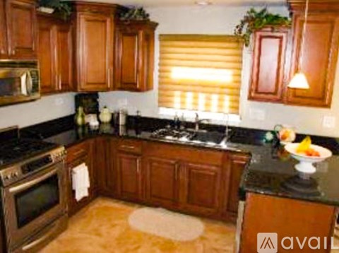 A kitchen with wooden cabinets and a black countertop.