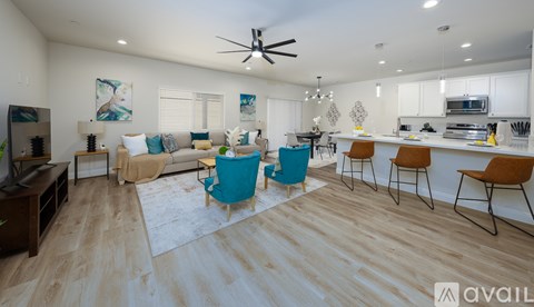 A living room with a blue chair and a white couch.