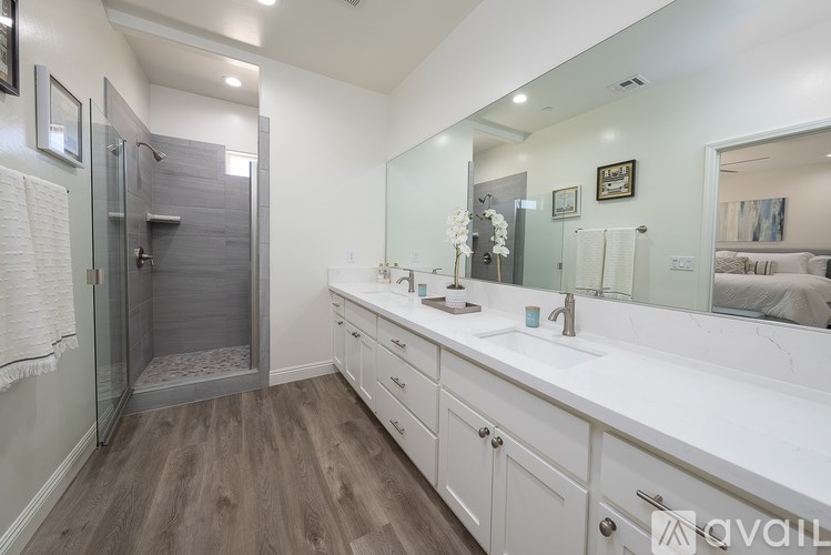 A bathroom with a walk-in shower and double sinks.