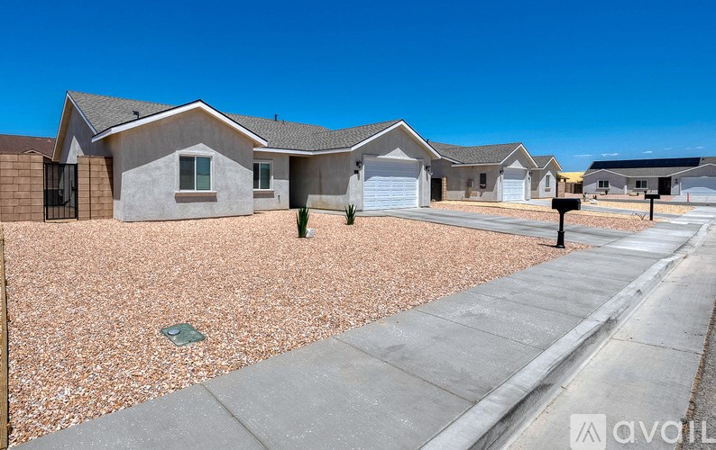 A row of houses with a gravel driveway in front.