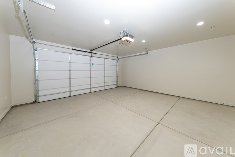 A large empty room with a white garage door.