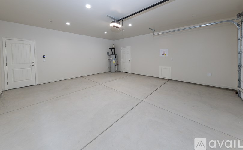 A large empty room with white walls and a concrete floor.