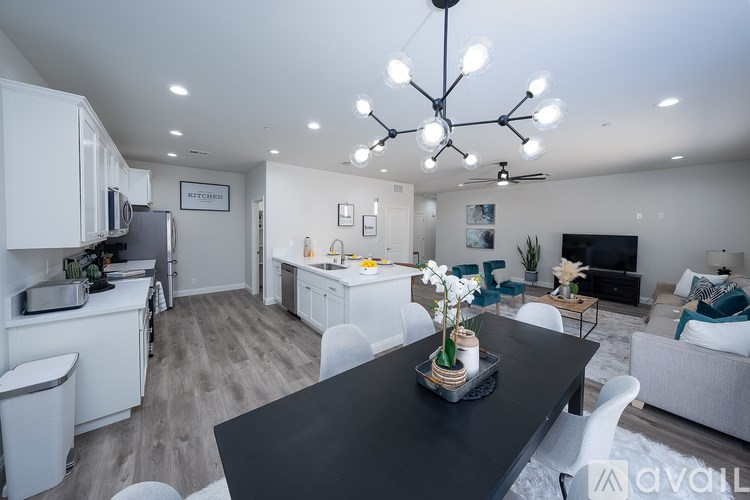 A modern kitchen with a black countertop and white cabinets.