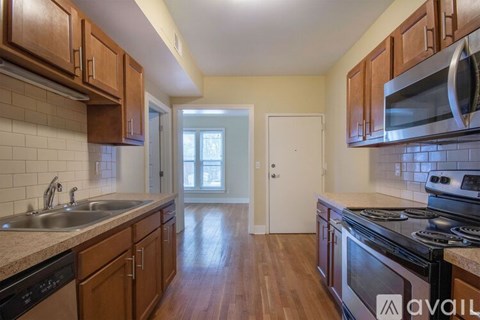 A kitchen with wooden cabinets and a black stove top oven.
