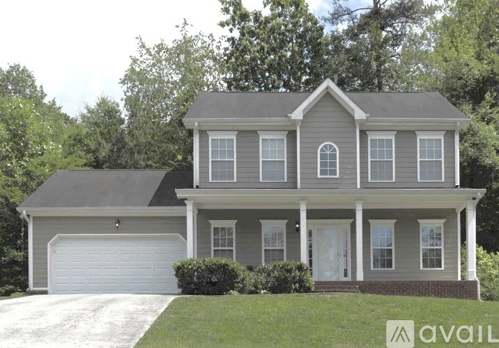 A two-story house with a garage on the first floor and a balcony on the second floor.