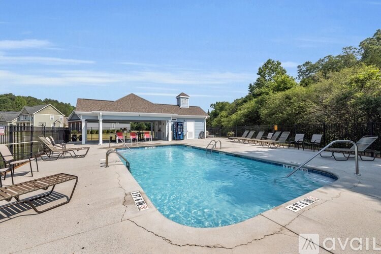A pool with lounge chairs and a building in the background.