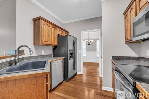 A kitchen with wooden cabinets and a black refrigerator.